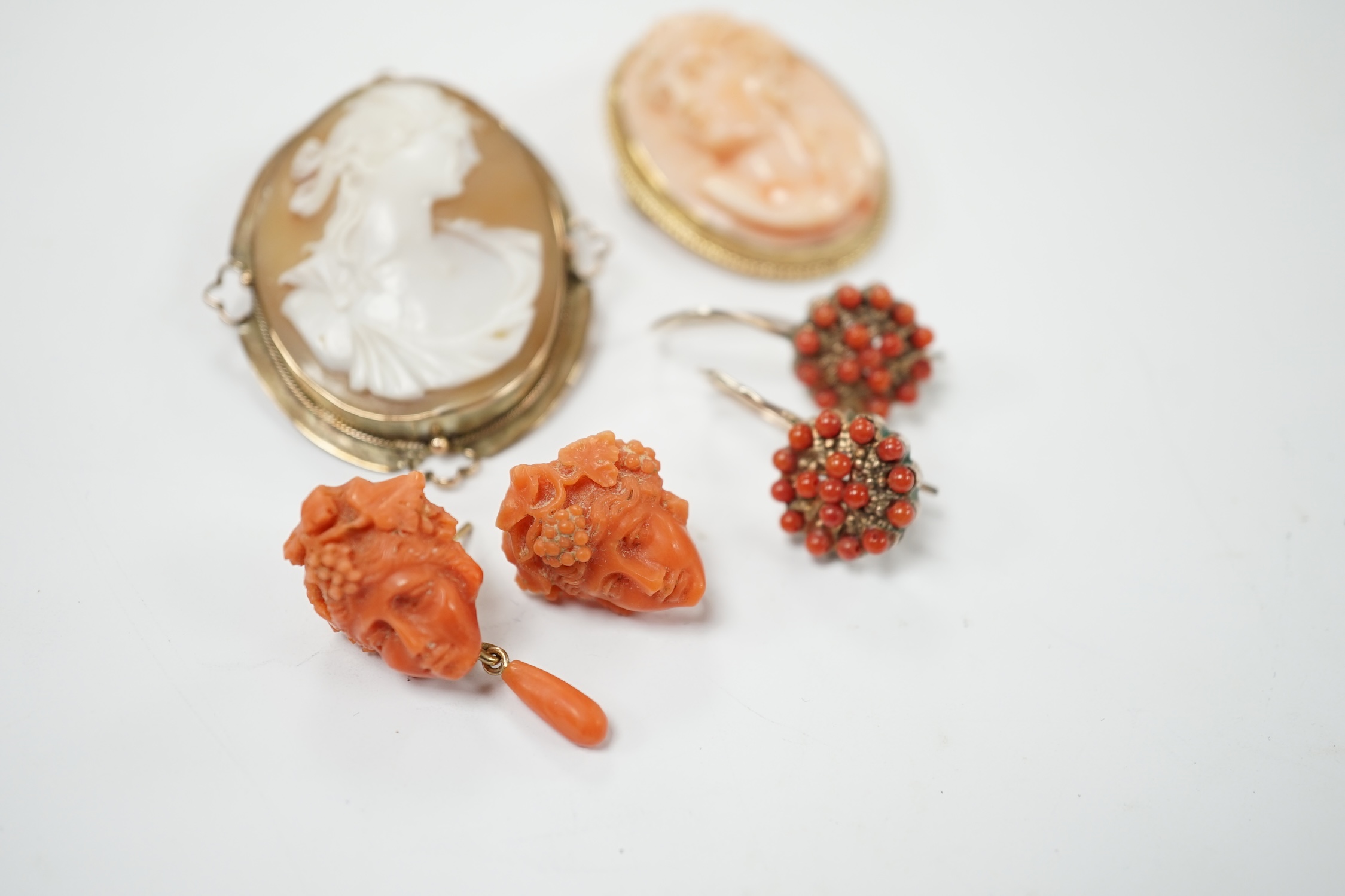 Two pairs of yellow metal and coral set earrings including carved bust (one badly chipped) and two 9ct mounted cameo shell/coral brooches. Poor condition.